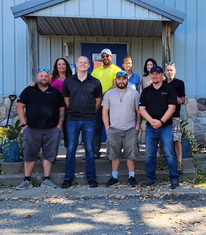 The Range Water Conditioning team poses together outside their office